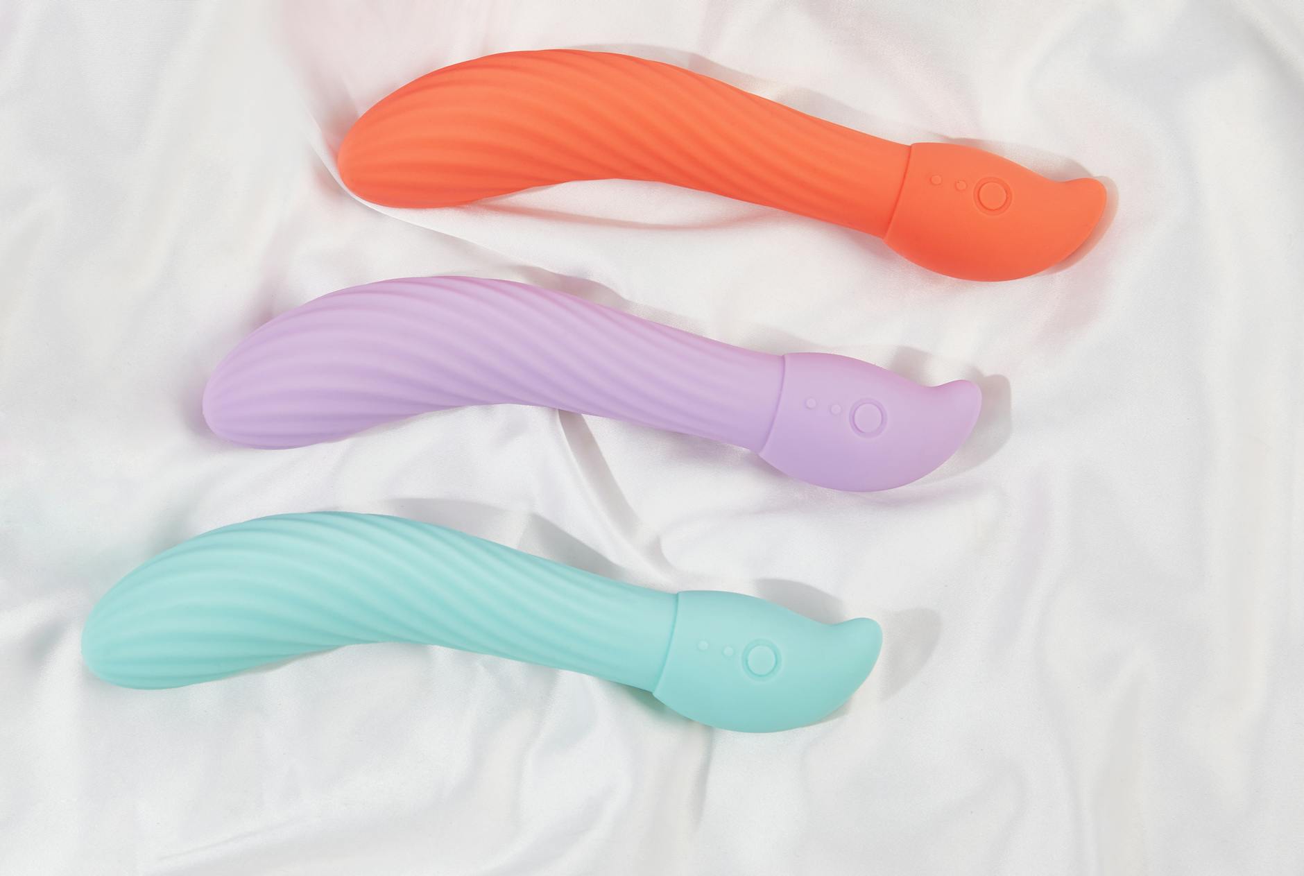 A teal lemon vibrator on smooth white silk fabric, demonstrating elegant design for intimate pleasure.