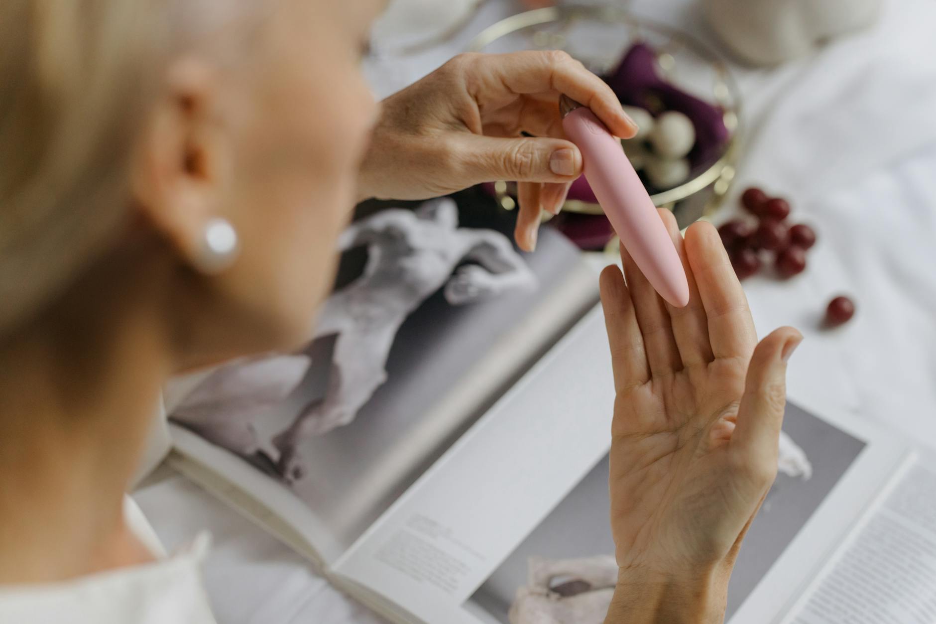 A woman holding a pink vibrator in natural light, symbolizing personal pleasure and recovery