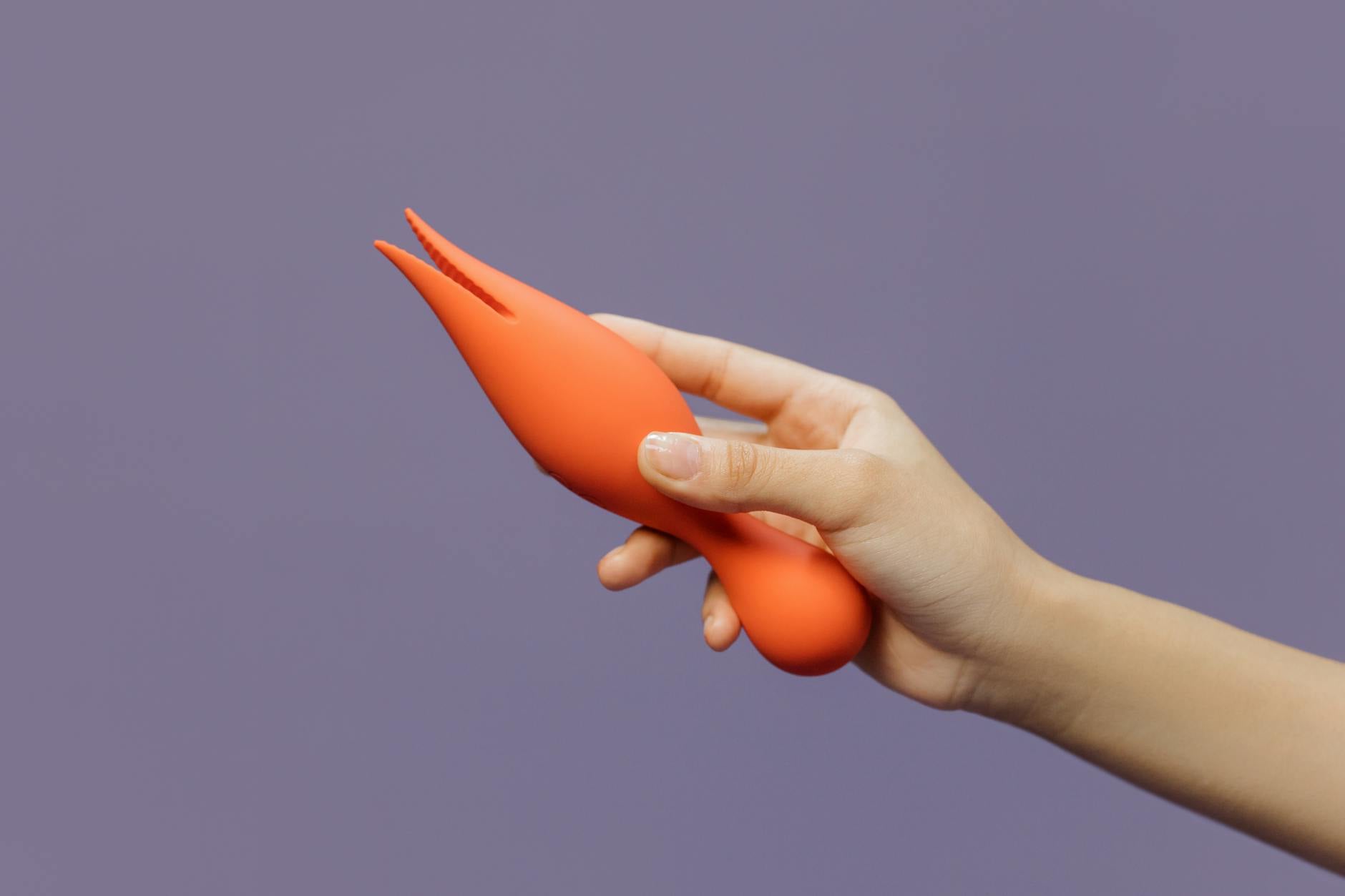 Close-up of a hand holding a vibrator against a minimalistic backdrop, symbolizing personal autonomy and reclaimed pleasure.