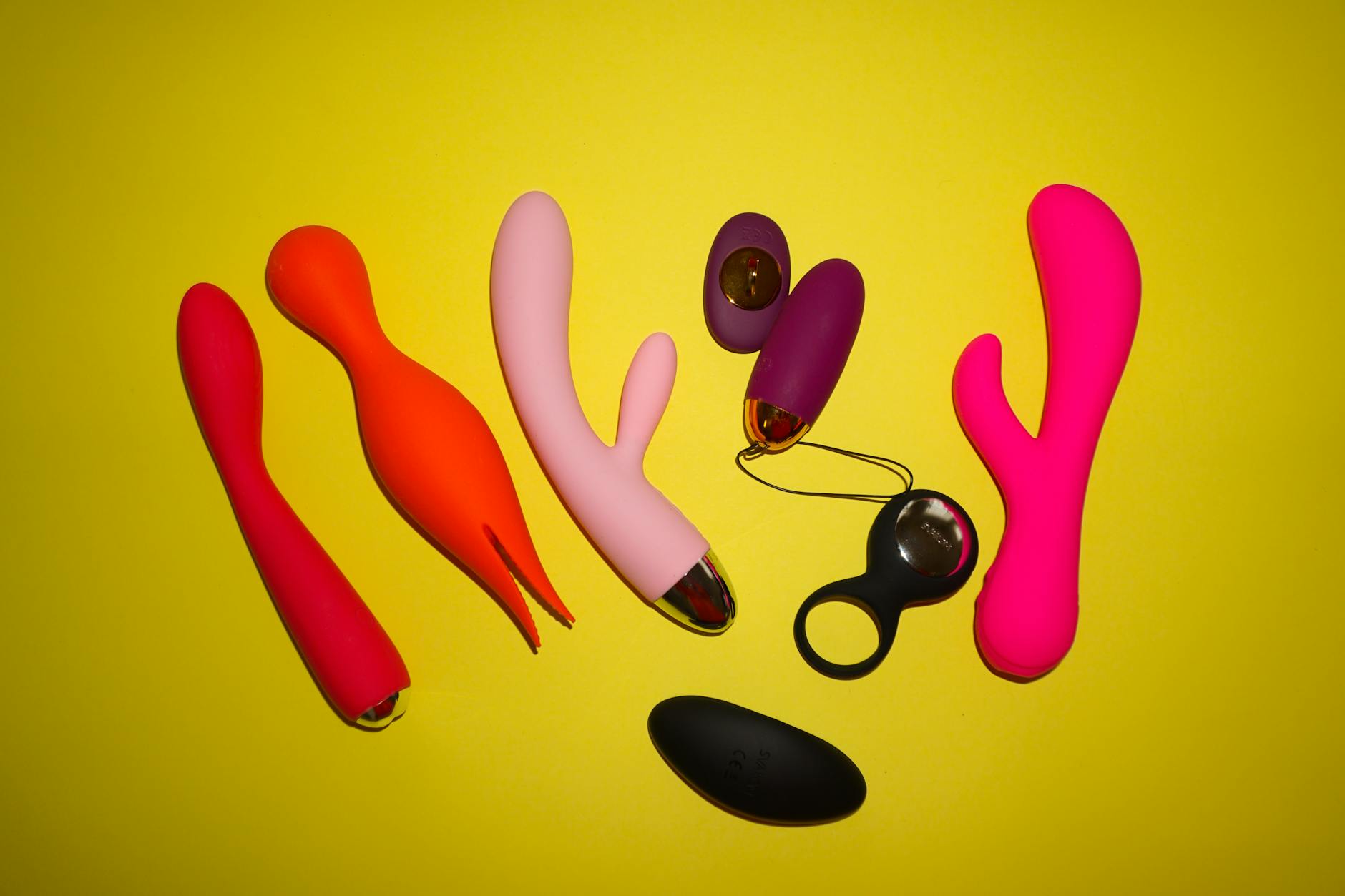 Couple holding a blue clitoral vibrator together indoors, representing intimacy during life transitions