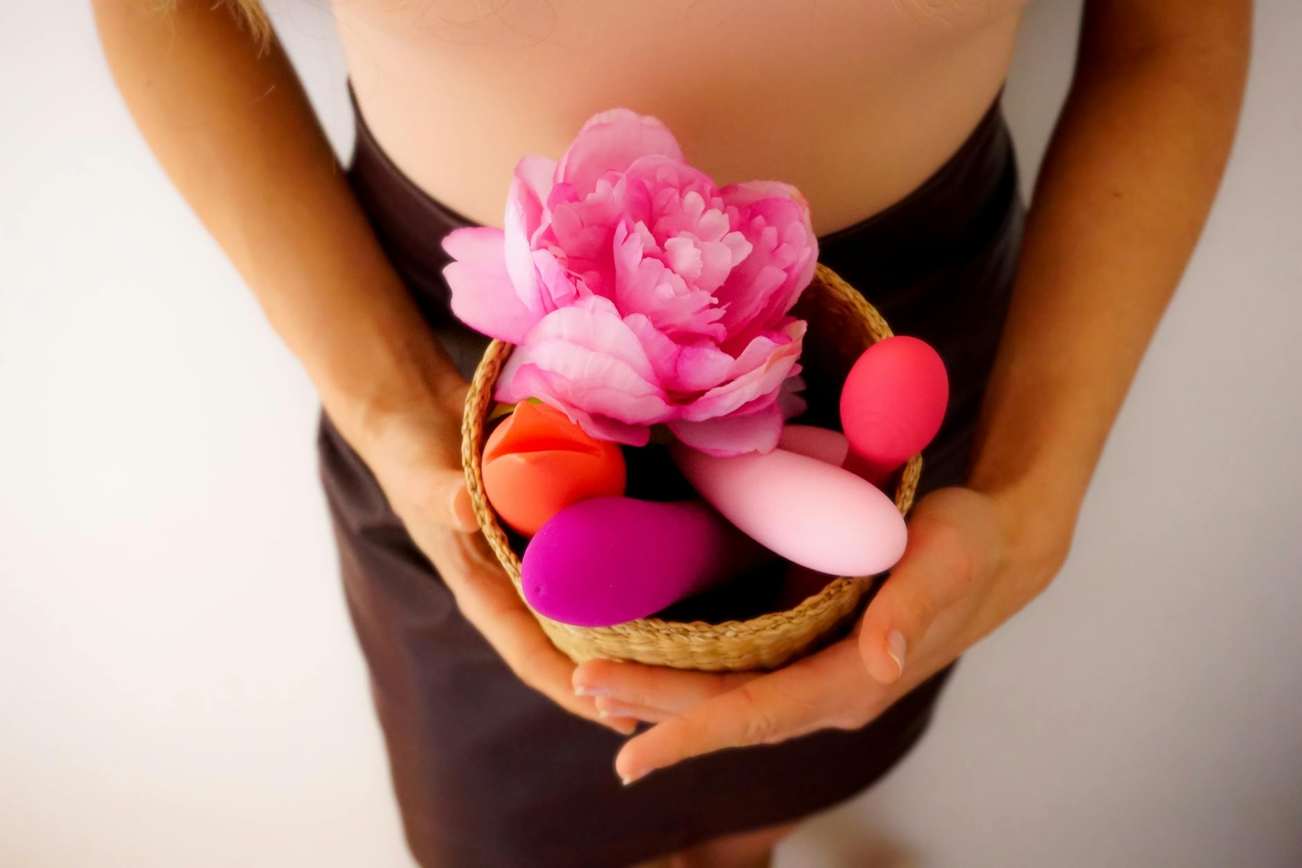 A blue vibrator surrounded by flowers on a yellow background, symbolizing pleasure and intimacy